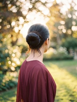 Hoher glatter Ballerina-Dutt auf dunklen langen Haaren