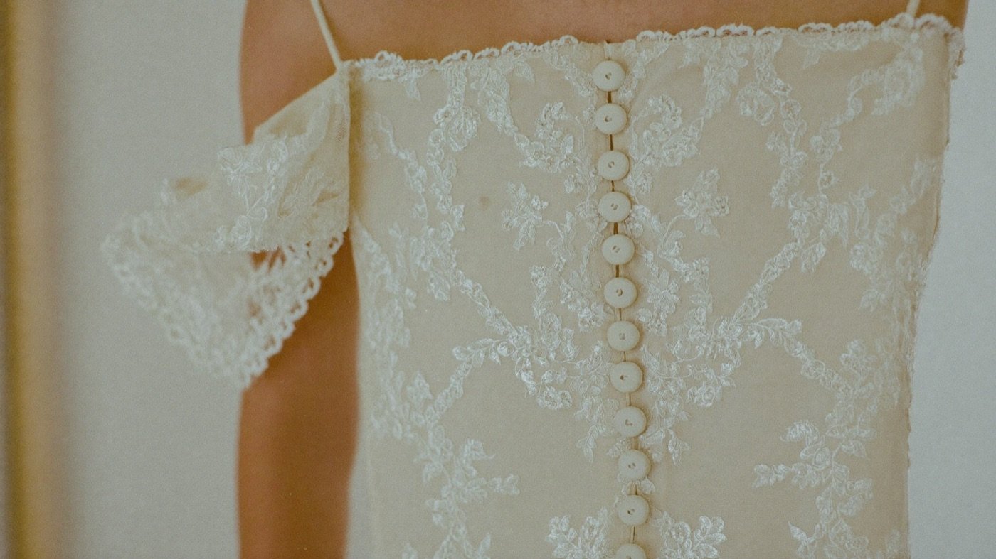 Spitzendetail eines Brautkleids mit Knopfleiste